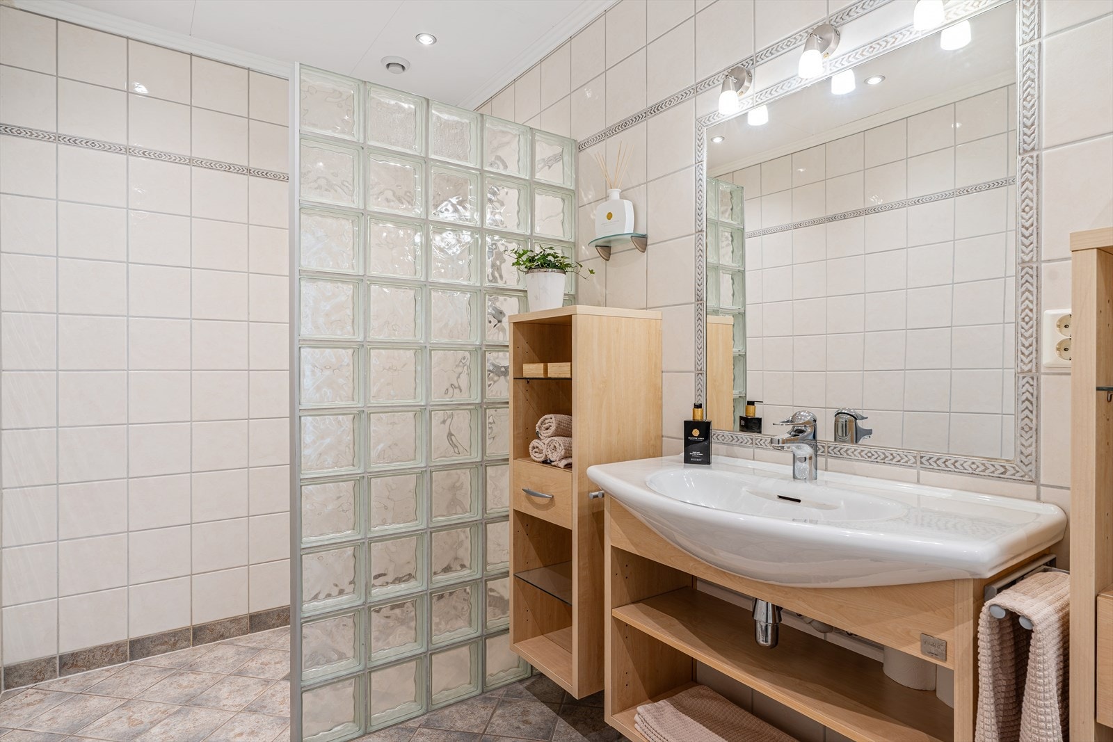 Badet er innredet med veggfestet servant, adskilt dusjssone og toalett. Galleribilde