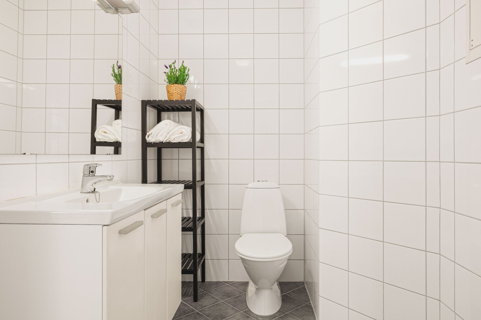 Badet i leiligheten er helfliset og har en slett malt himling. Det er selvfølgelig varme i gulv. Galleribilde