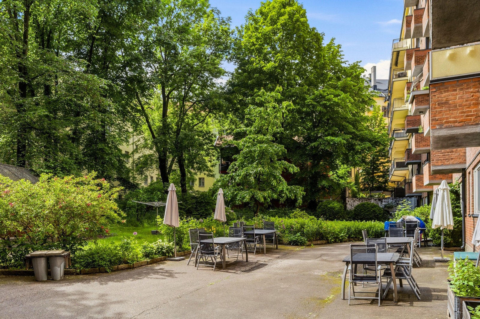 Hyggelig og frodig bakhage med sittegrupper og sykkelparkering Galleribilde