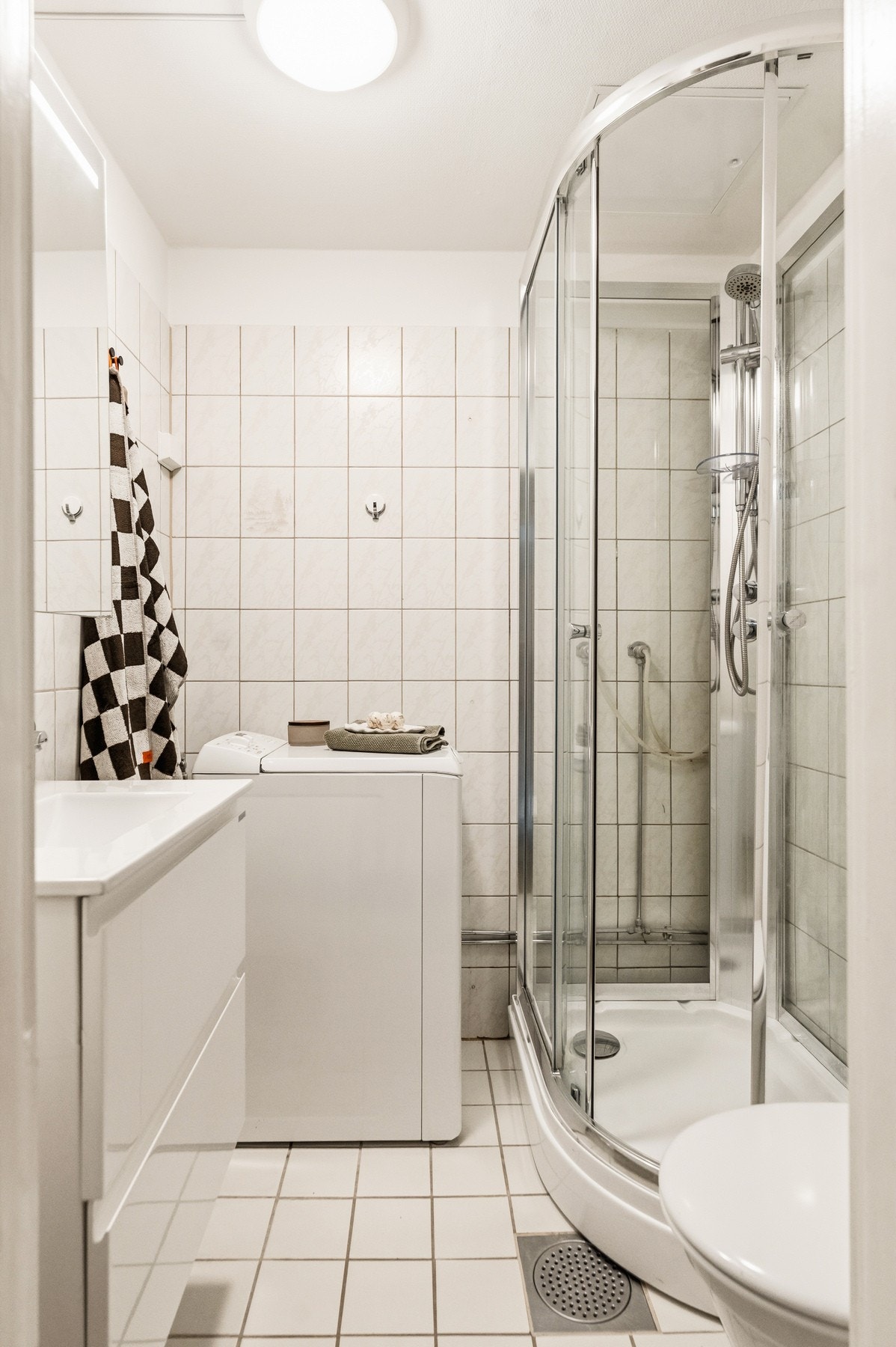 Baderom fra 2004 med toalett, heldekkende servant med underskap, dusjkabinett samt oppleg for vaskemaskin og tørketrommel. Naturlig ventilasjon. Galleribilde