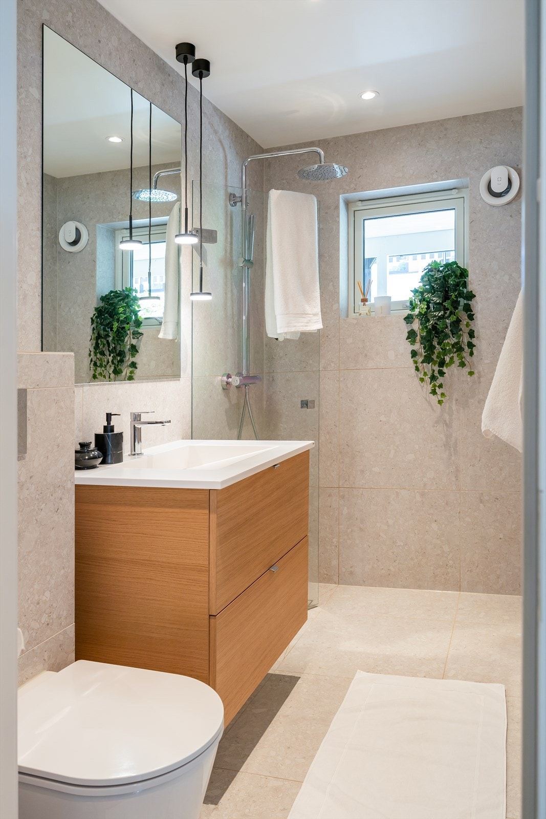 Badet er utstyr med dusjnisje, mekanisk avtrekk, servant, servantskap og veggmontert wc. Galleribilde