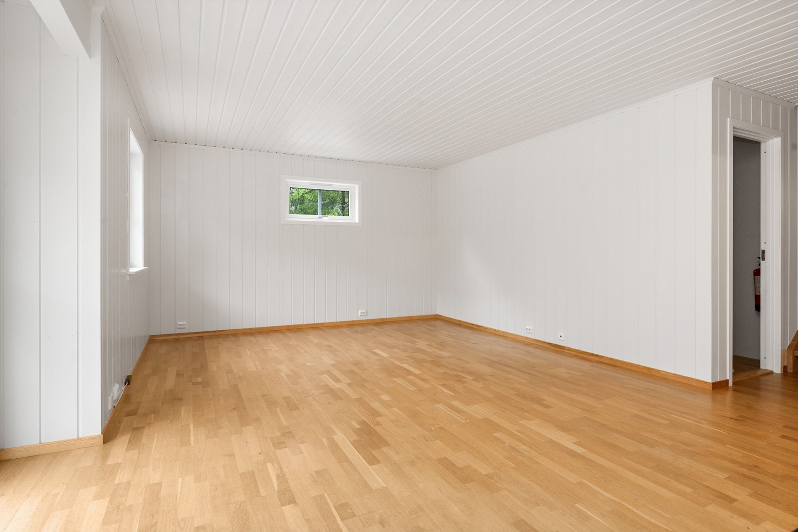 Gjennomgående trepanel i himling og på vegger gir en helhetlig og lun følelse i oppholdsrommene. Galleribilde