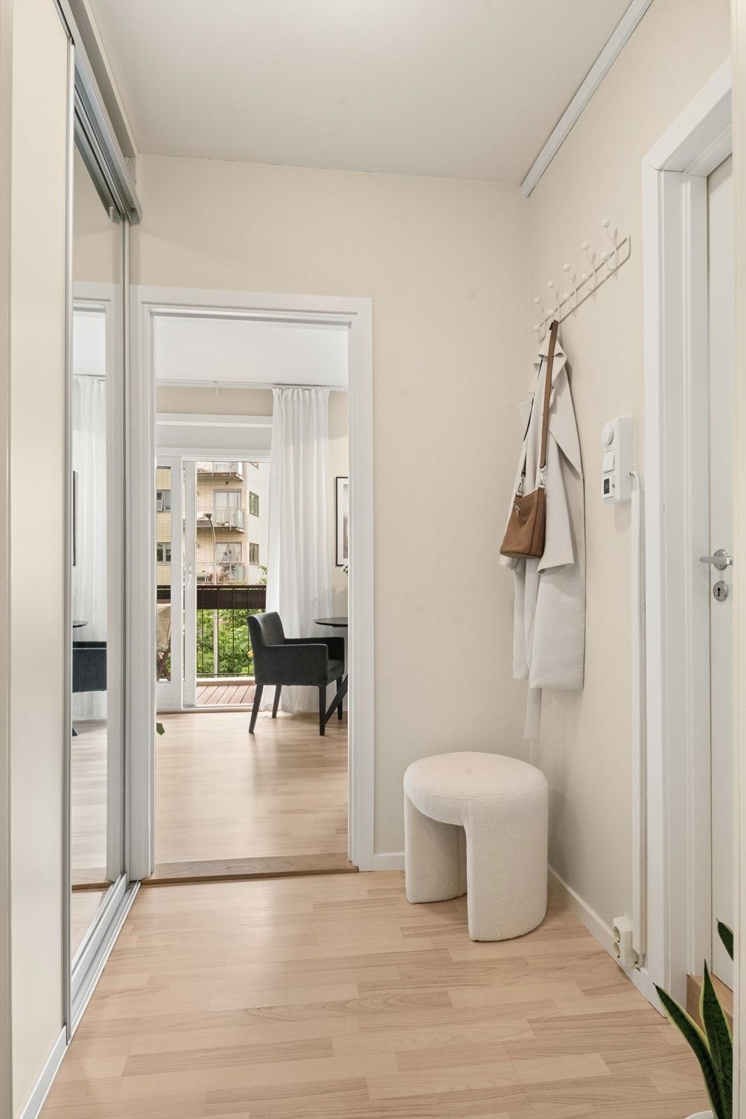 Velkommen inn i en lys entré med skyvedørsgarderobe med speilfronter. Galleribilde