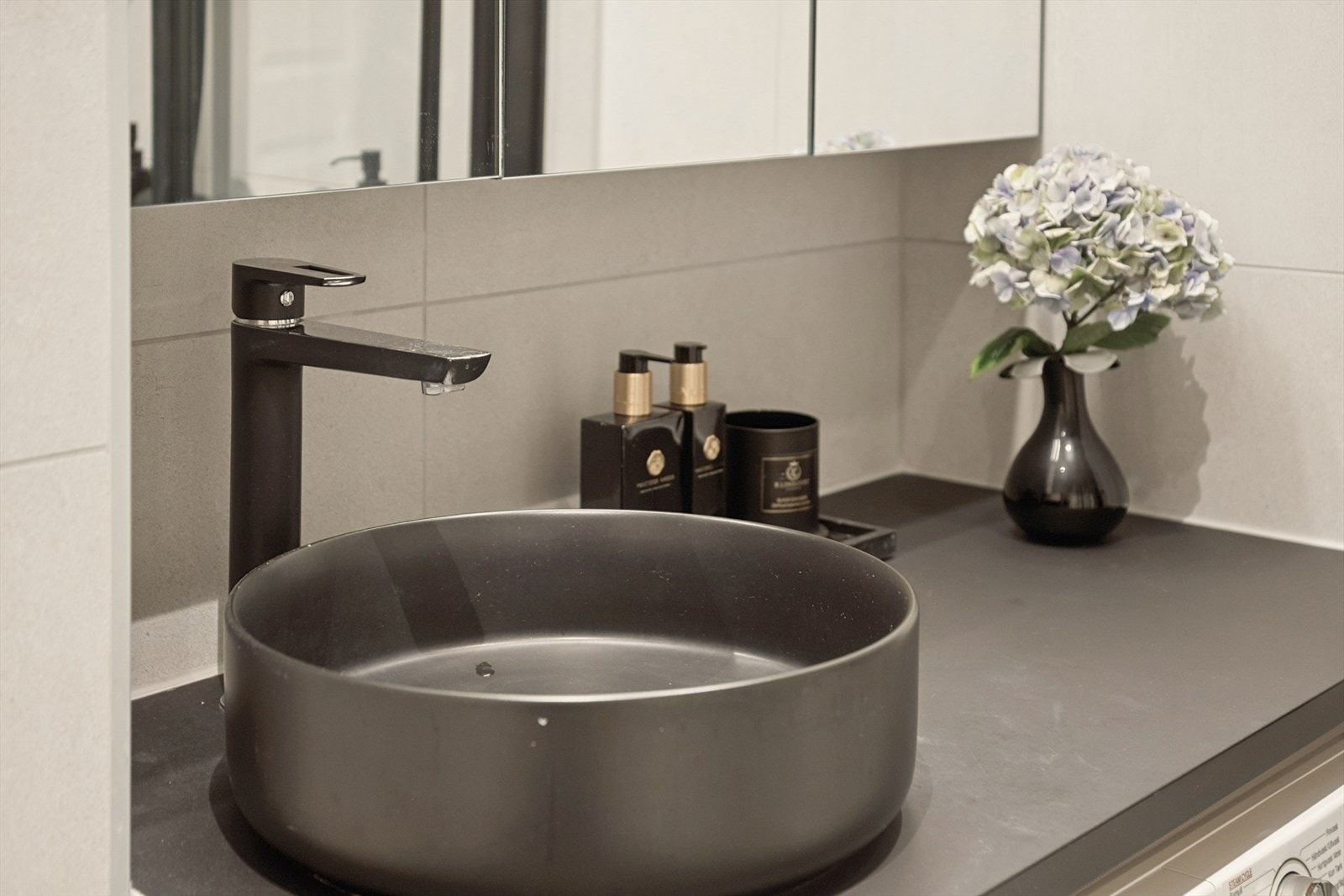 Badet er utstyrt med servant, vegghengt toalett, dusjhjørne med glassvegger og opplegg for vaskemaskin. Vaskemaskin medfølger. Galleribilde
