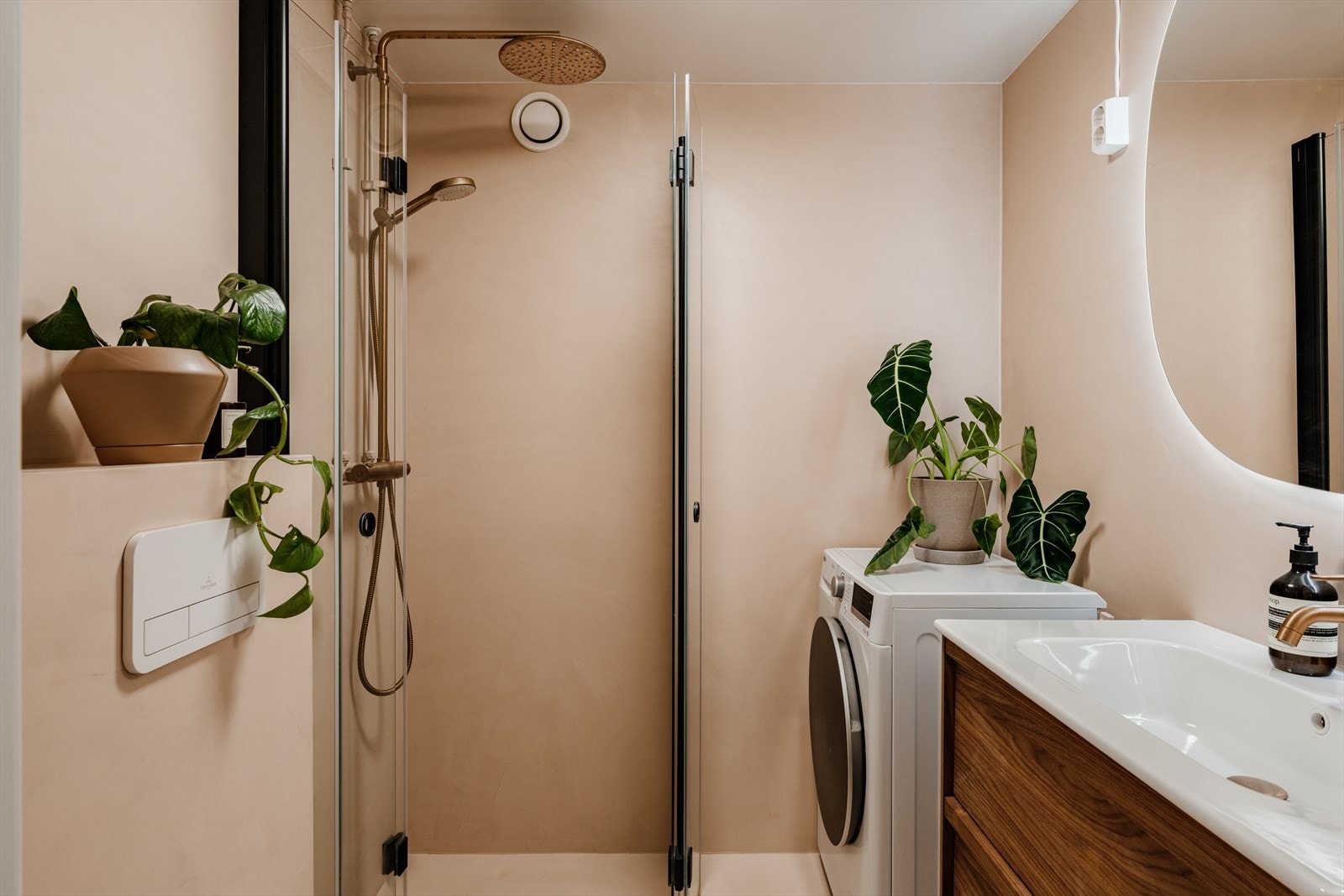 Videre er det opplegg for vaskemaskin og vegghengt toalett. Badet fremstår moderne og gjennomført med sorte detaljer og armaturer i varme metalltoner som tilfører særpreg og karakter. Galleribilde