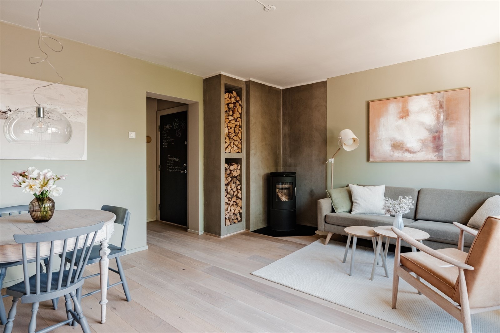 Lys og romslig stue med store vindusflater som slipper inn rikelig med naturlig lys og gir hyggelig utsyn mot grønne omgivelser. Rommet har en behagelig atmosfære med delikate, varme fargetoner og gjennomgående pene overflater. Galleribilde
