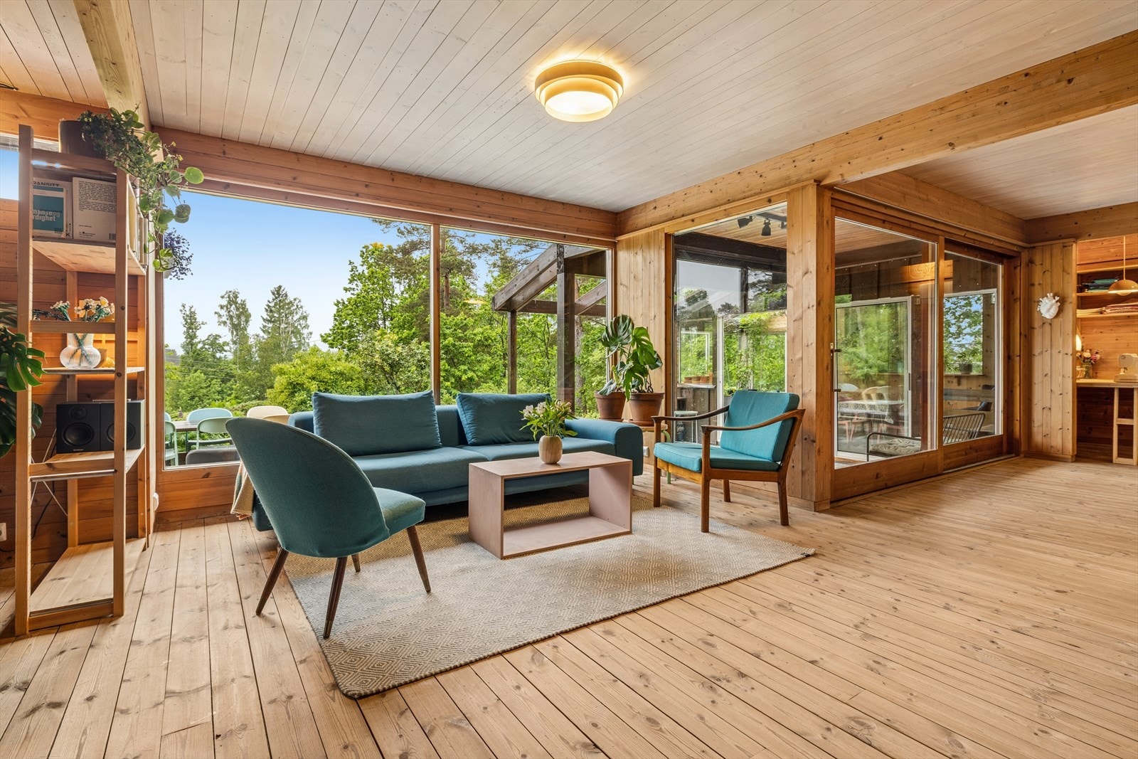 Stuen er lys og romslig - Store vinduer fra gulv til tak gir rikelig med lys og en følelse av å ha naturen tett på. Galleribilde