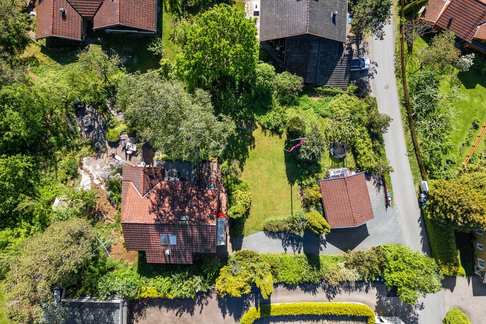 Dronebilde av tomtens størrelse og den etablerte beplantningen som omslutter boligen. Galleribilde