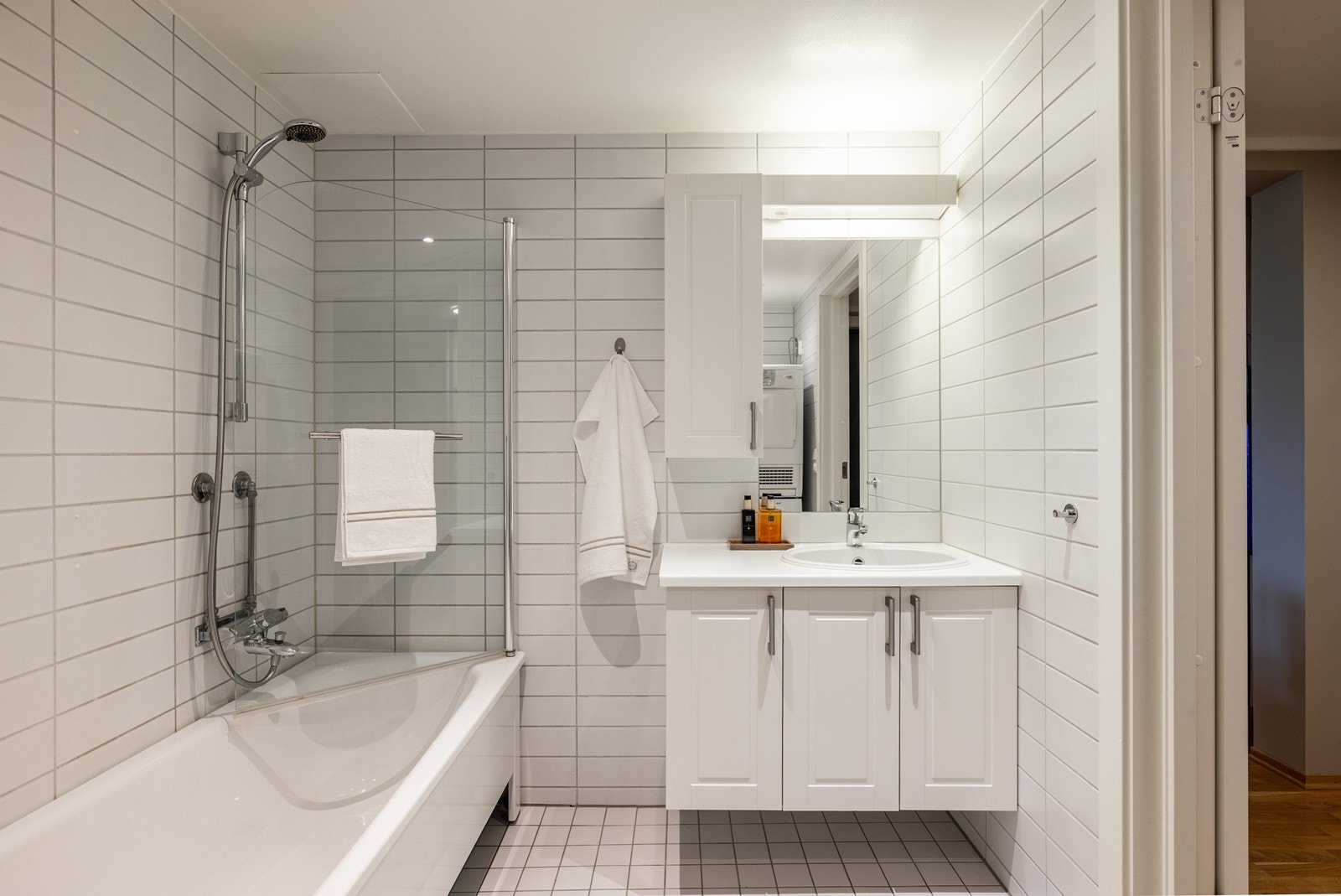 Badet har en god størrelse og byr på en ekstra luksus i hverdagen med et kombinert badekar og dusj, skjermet av en praktisk og stilren dusjvegg i glass. Galleribilde