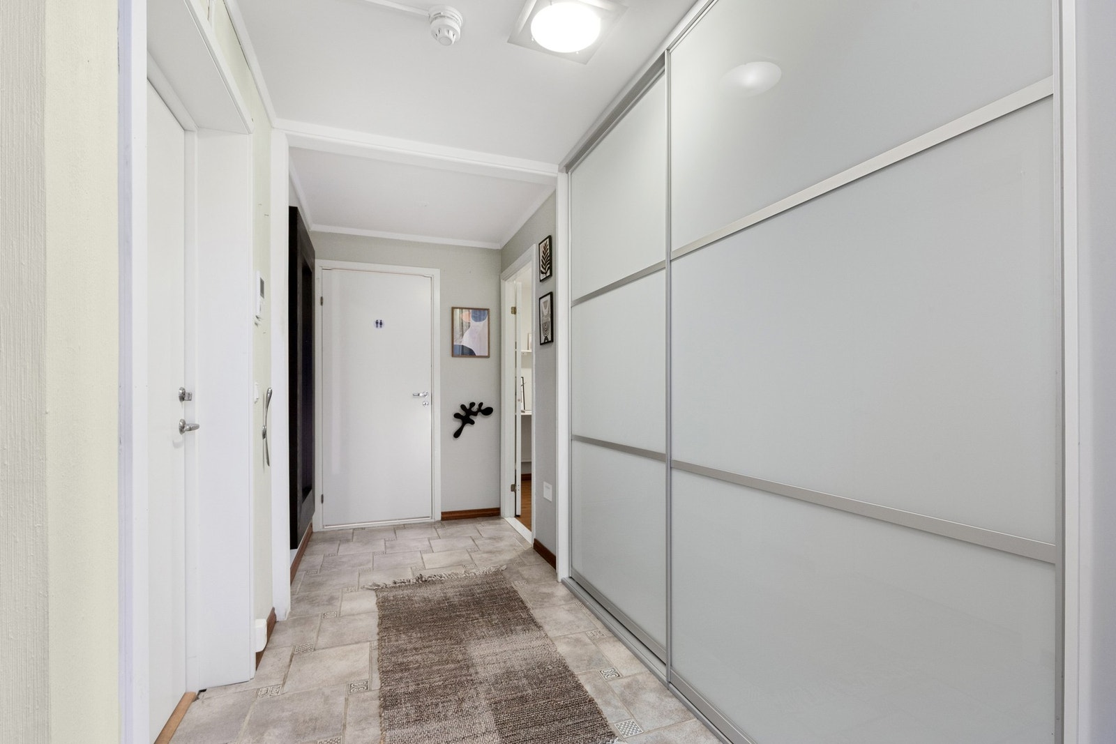 Entréen er tiltalende, med plass til oppbevaring av sko og yttertøy.
Skyvedørsgarderobe som bidrar til oppbevaring og holder entréen ryddig og oversiktlig. Galleribilde