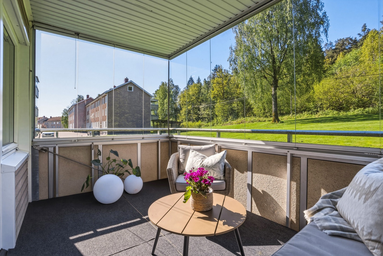 Balkongen byr på gode solforhold og et hyggelig utsyn over borettslagets felles grøntarealer. Galleribilde