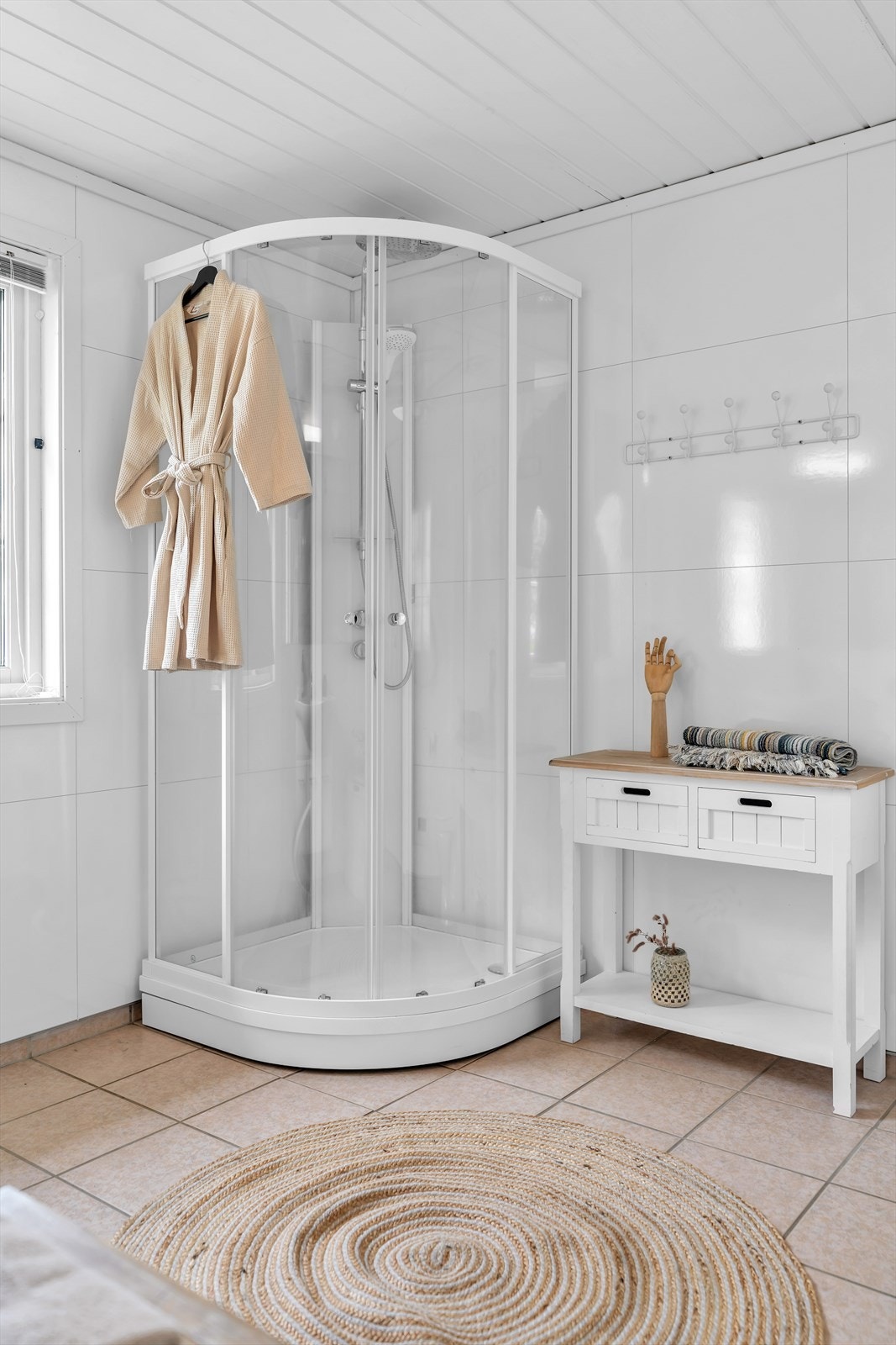 Badet har baderomsplater på veggene og dusjkabinett. Galleribilde