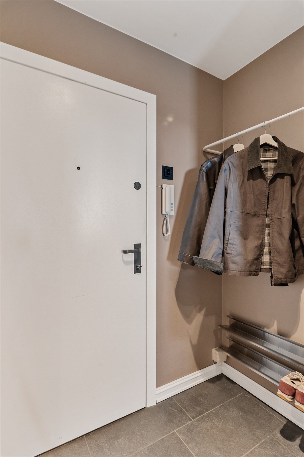 Entréen har plass til oppbevaring av yttertøy og sko. Dørcalling med portåpner er installert. Galleribilde
