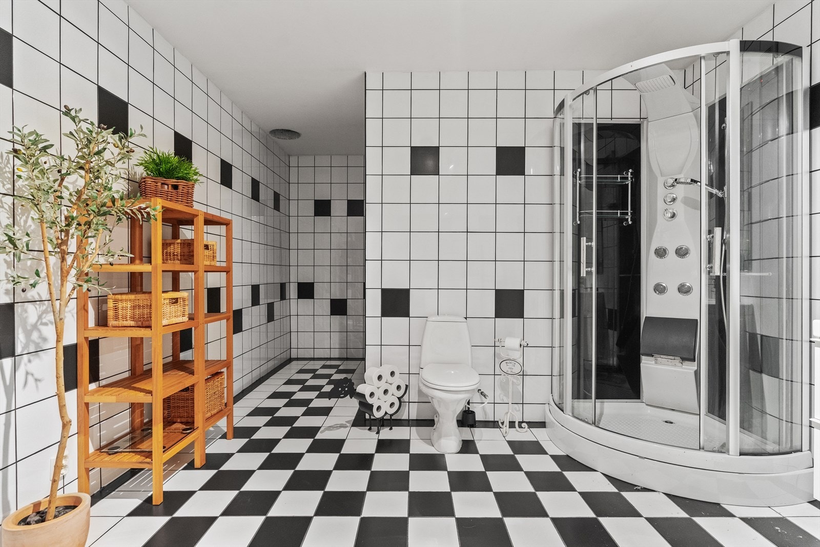 Videre har badet gulvmontert toalett, dusjkabinett med skyvedører, håndholdt dusj og termostatstyrt blandebatteri. Galleribilde