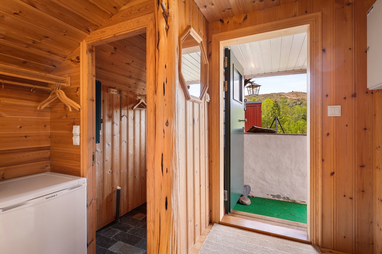 Fra vindfanget er det inngang til en praktisk garderobe med flislagt gulv og varmekabler. Galleribilde