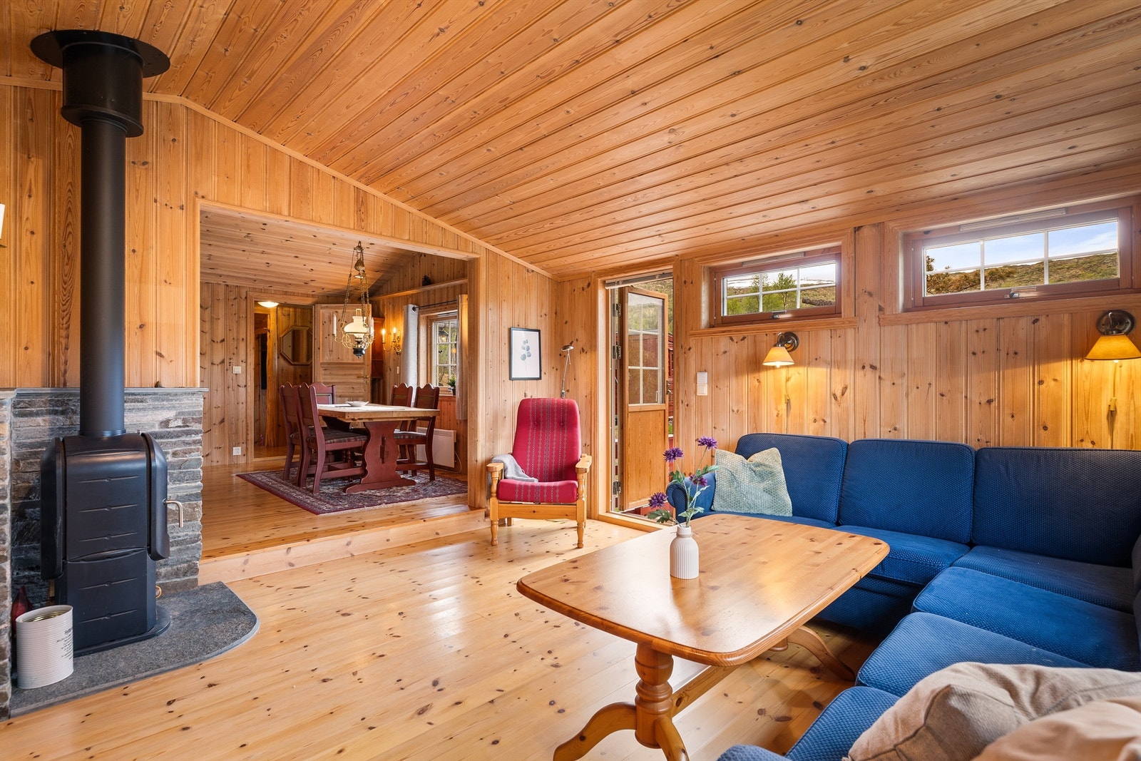 Åpen løsning mellom stue og spisestue skaper en sosial og romslig atmosfære. En effektiv vedovn sørger for både varme og hygge på kalde dager. Galleribilde