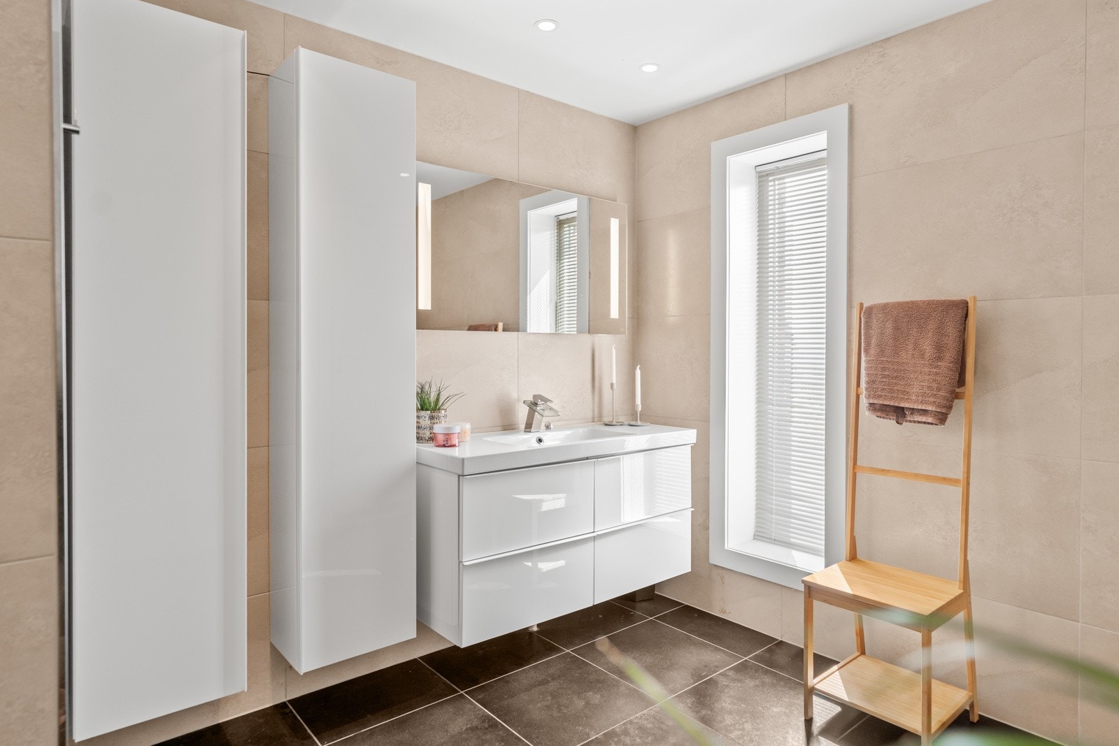 Videre har badet innredning med skuffer og heldekkende servant. Over servanten er det speil med integrert belysning, samt downlights i himling. Galleribilde