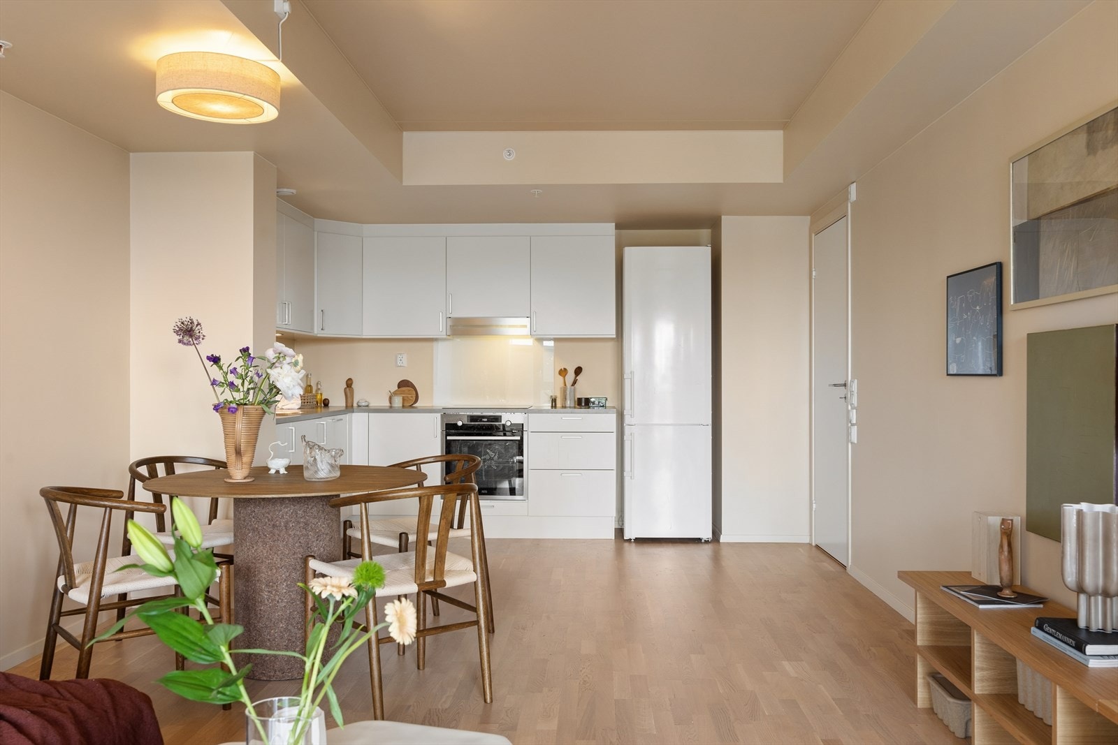 Kjøkkeninnredning fra 2019 har hvite glatte fronter med lys under overskapet. Benkeplaten er i laminat med nedfelt oppvaskkum og ettgreps blandebatteri. Galleribilde