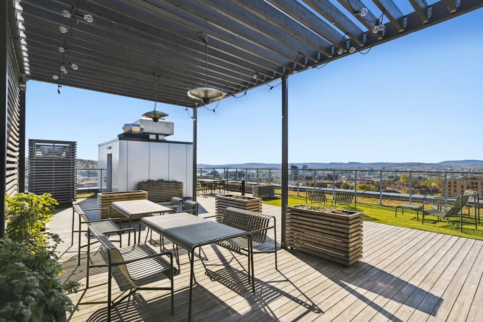 Sameiet har to felles takterrasser i 8. og 17. etasje til glede for beboerne. En av sameiets felles takterrasser, innredet med sittegrupper, pergola og beplantning. Galleribilde