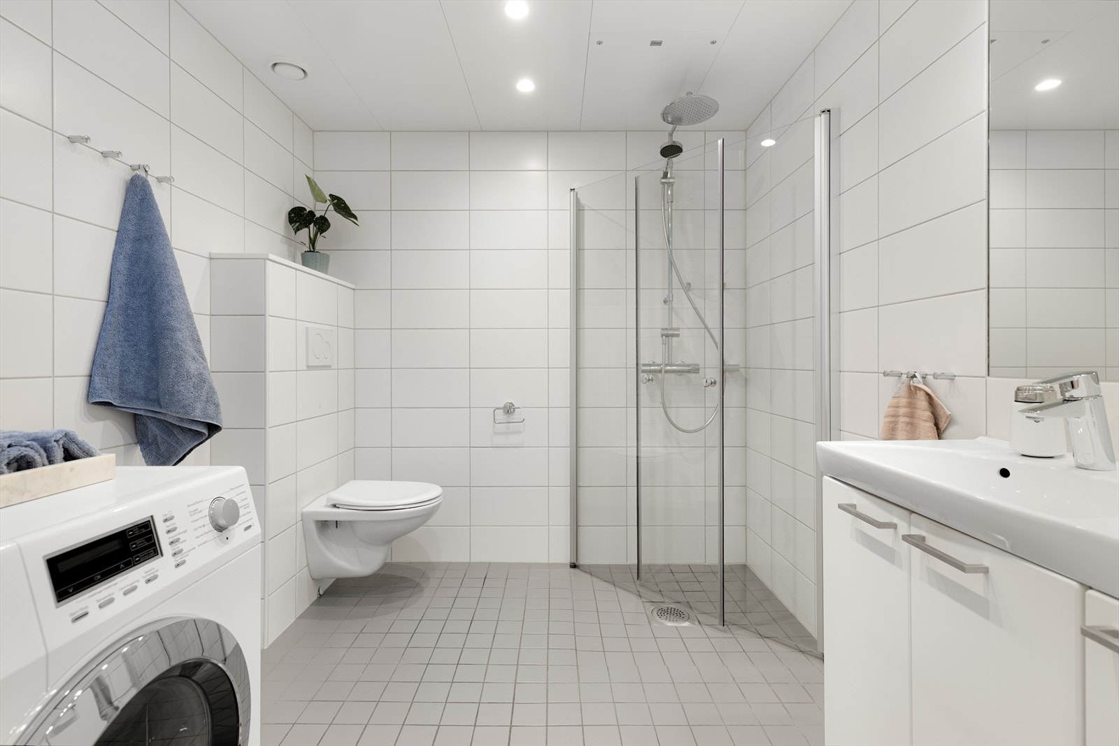 Flislagt bad med elektrisk gulvvarme og opplegg for vaskemaskin. Galleribilde
