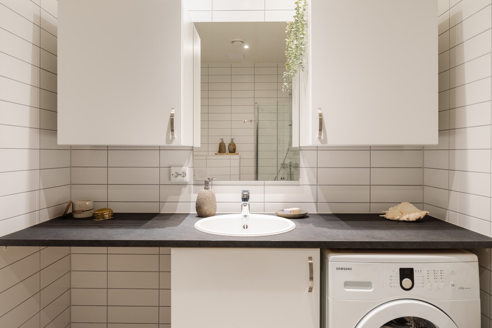 Badet er innredet med servant, speilskap og har opplegg for vaskemaskin. Galleribilde
