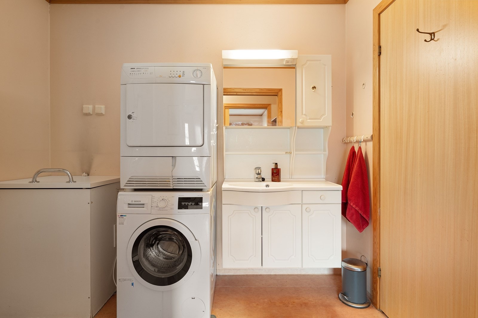 Badet er på 5,5 kvm og har våtromsbelegg på gulv, malt strie på vegger og malt betong i himling. Rommet er innredet med servant og tilhørende møblement, speil med belysning, toalett. vaskemaskin, tørketromm og et dusjkabinett, med tilhørende dusjgarnityr. Galleribilde