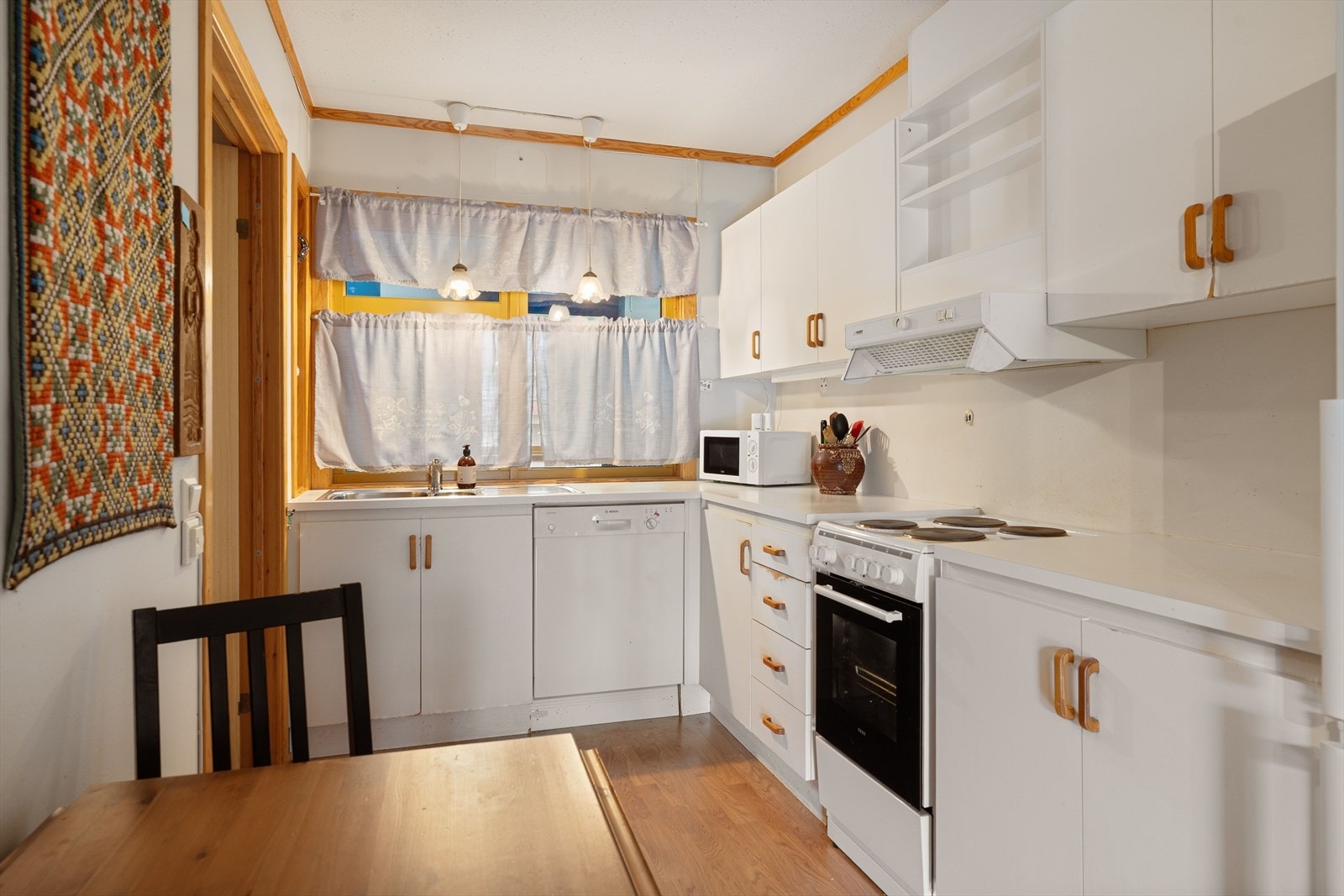 Kjøkkeninnredningen er original fra byggeår og består av slette, hvite fronter, laminat benkeplate, stål vaskekum og ventilator. Det er opplegg for oppvaskmaskin. Galleribilde