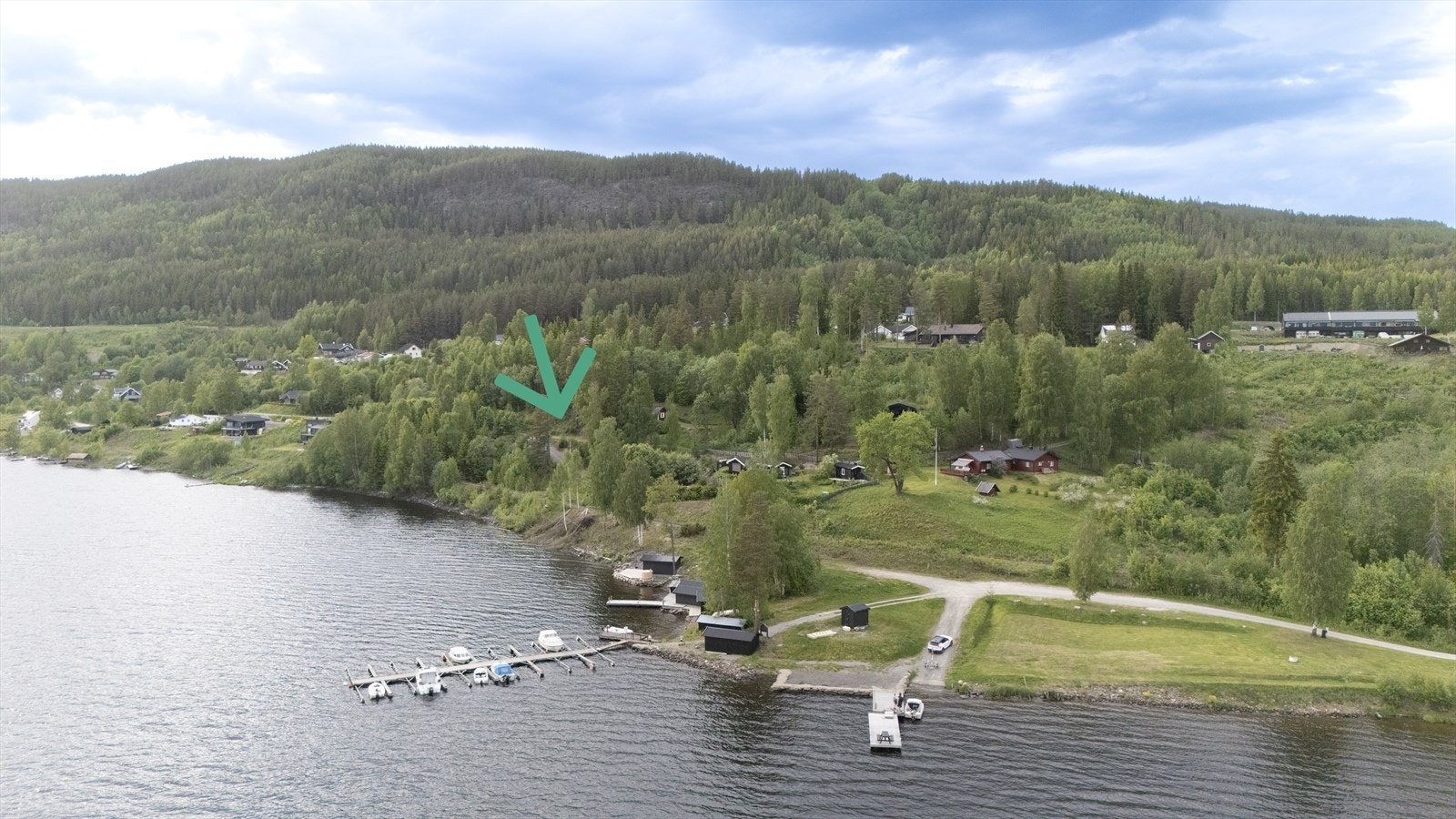 Dronebilder som viser Odnes båthavn og badeplassen til venstre. Hytta er markert med pil, og i bakkant sees Odnesberget med flotte turmuligheter og utsiktspunkt. Galleribilde