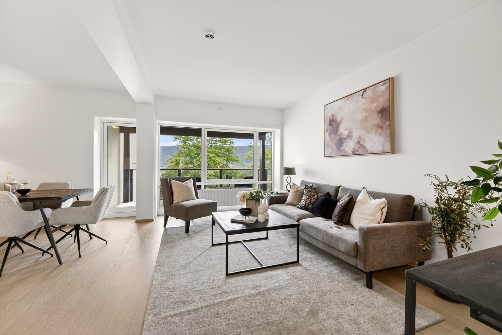 Boligens stue fremstår som lys, romslig og svært innbydende med en moderne planløsning som legger til rette for både avslapning og sosialt samvær. Galleribilde