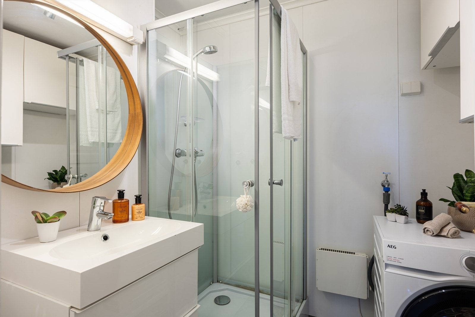 Badet har innredning, dusjkabinett og plass til vaskemaskin Galleribilde