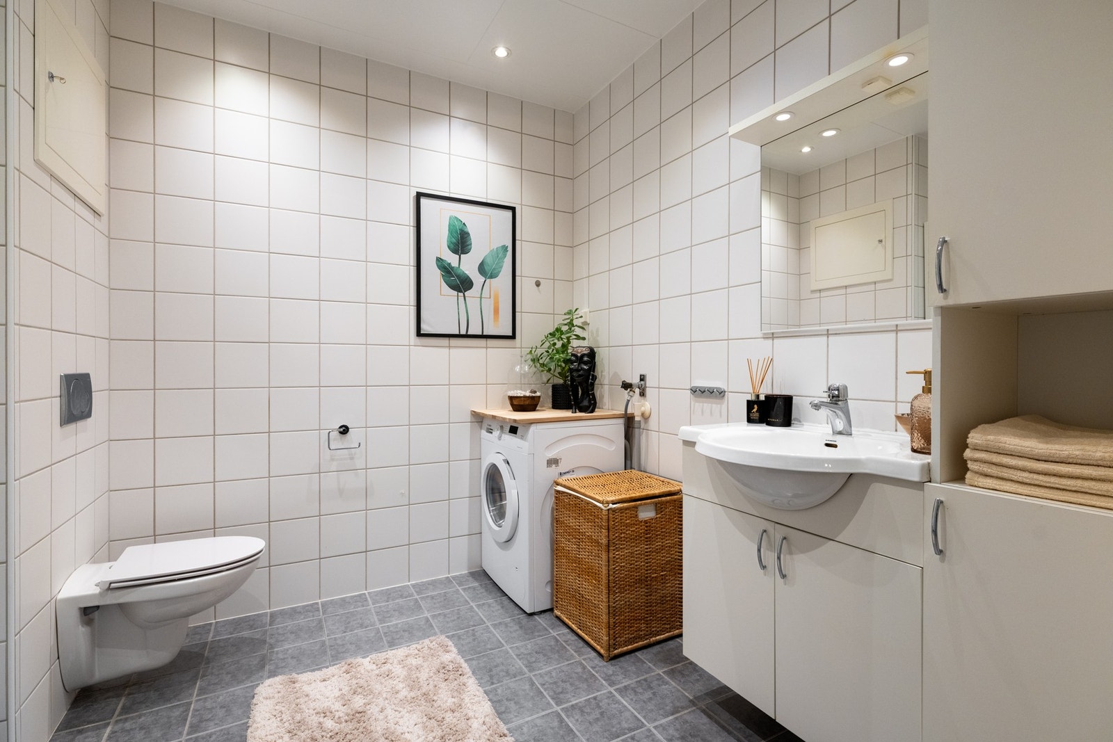 Lyst, flislagt baderom med varme i gulv og downlights i himling. Det er opplegg for vaskemaskin. Galleribilde