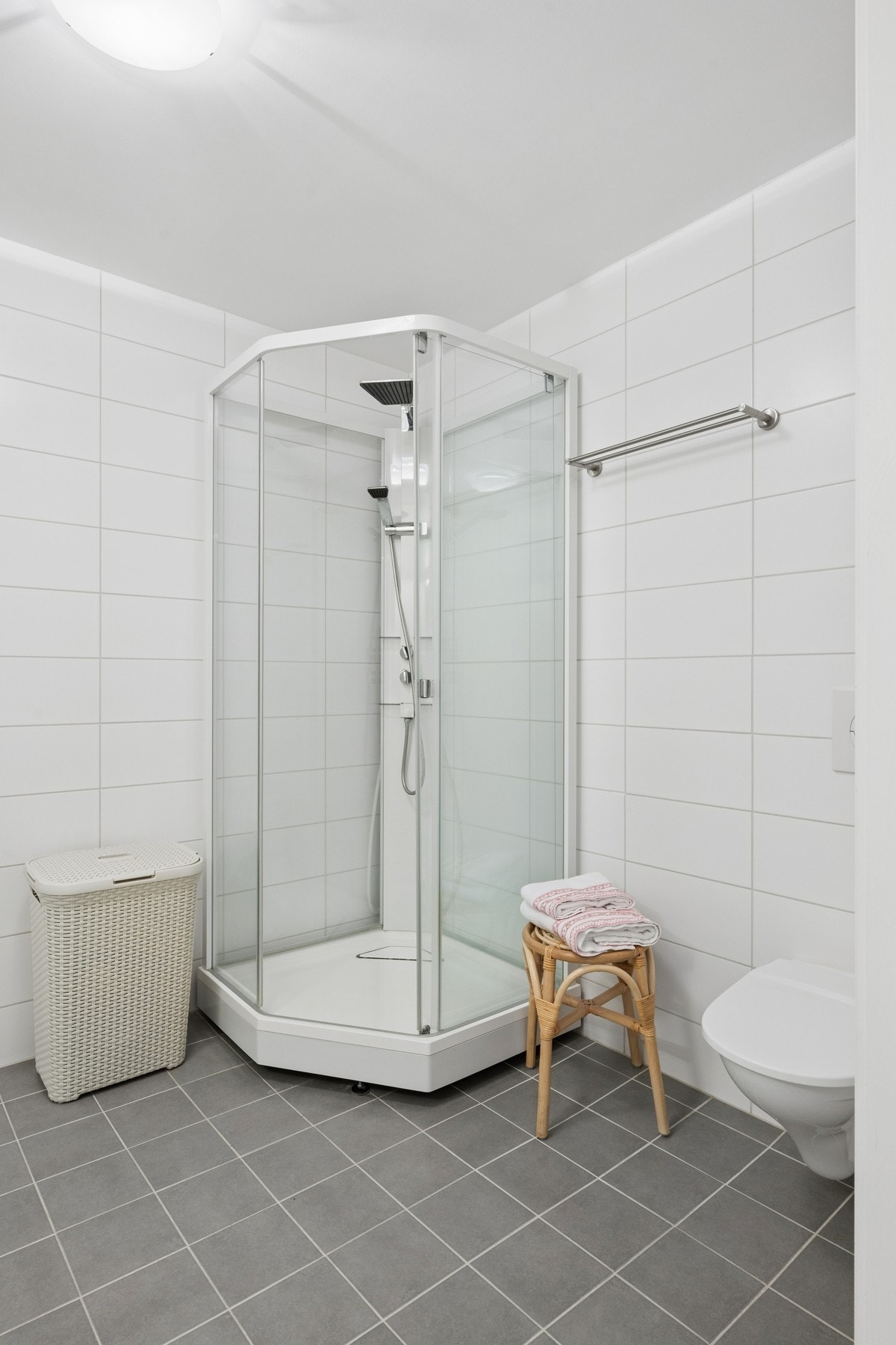 Badet er utstyrt med dusjkabinett og vegghengt toalett for enkelt renhold. Galleribilde