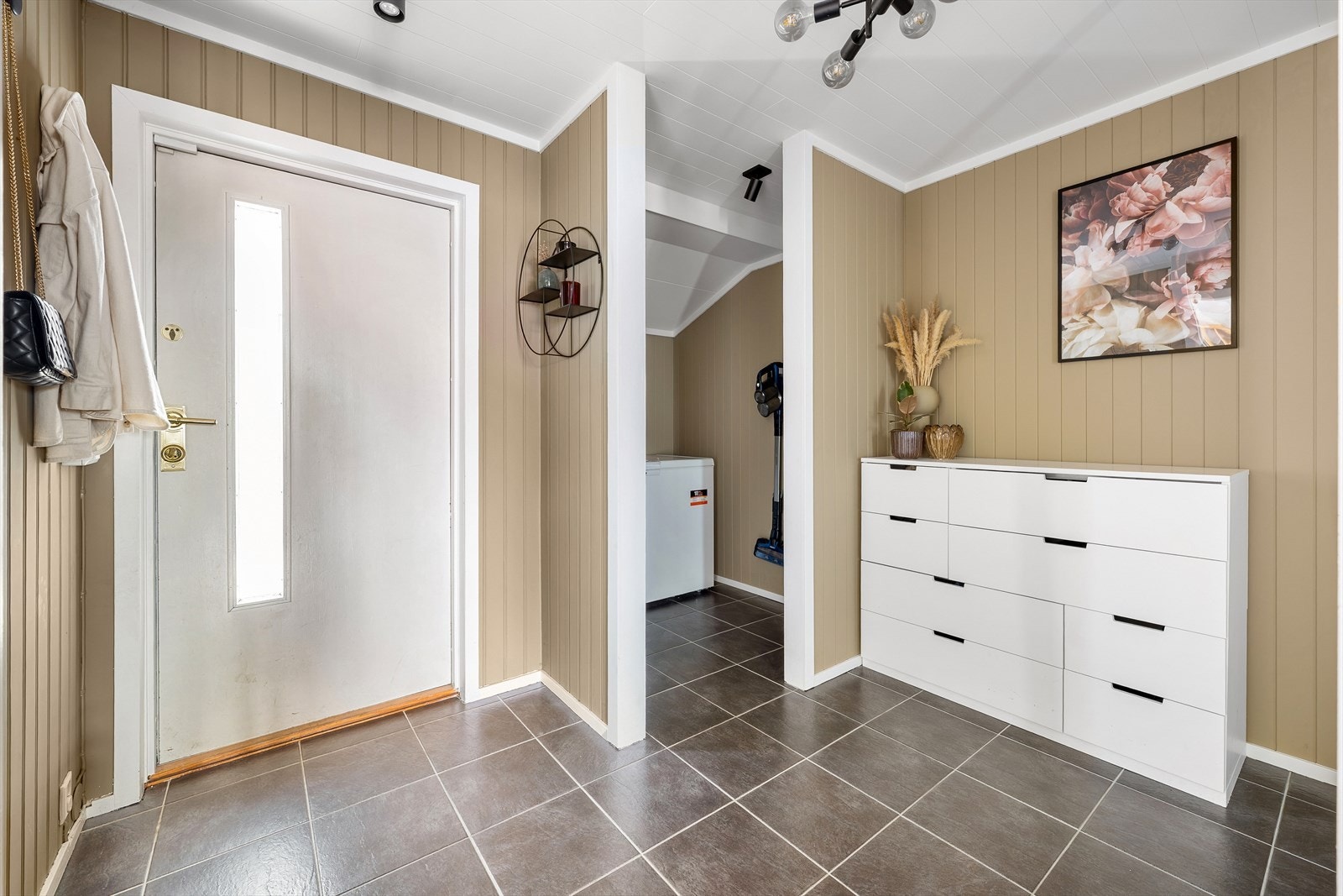 Her ønskes man velkommen inn i en praktisk entré med opphengsløsning, kommode og skyvedørsgarderobe med speildører for oppbevaring av yttertøy. Galleribilde