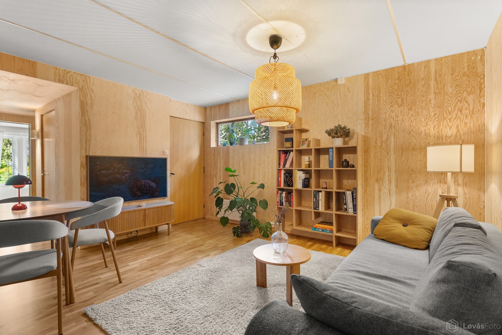 Hall som selger benytter som stue er lyst og innbydende uttrykk med vegger kledd med plater og parkett på gulvet som gir en lun og helhetlig følelse. Galleribilde