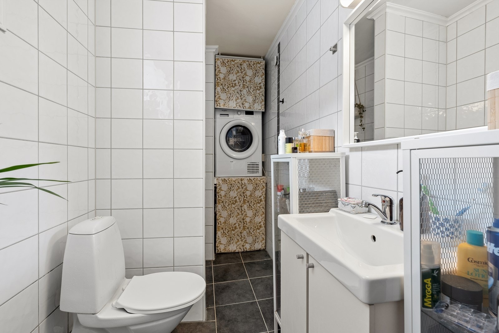 Badet kombinerer bad og vaskerom (fra 1990-tallet) og er innredet med innredning med nedfelt servant, nedsenket dusjhjørne med glassvegger, toalett og vaskemaskin. Galleribilde