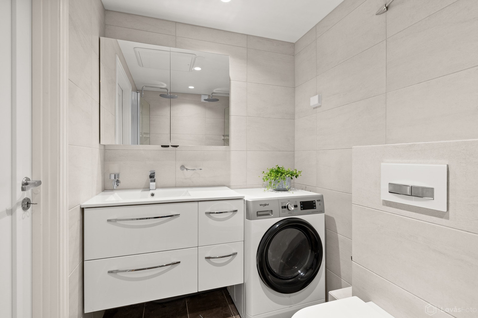 Badet har vegghengt toalett, servantinnredning og opplegg for vaskemaskin. Galleribilde