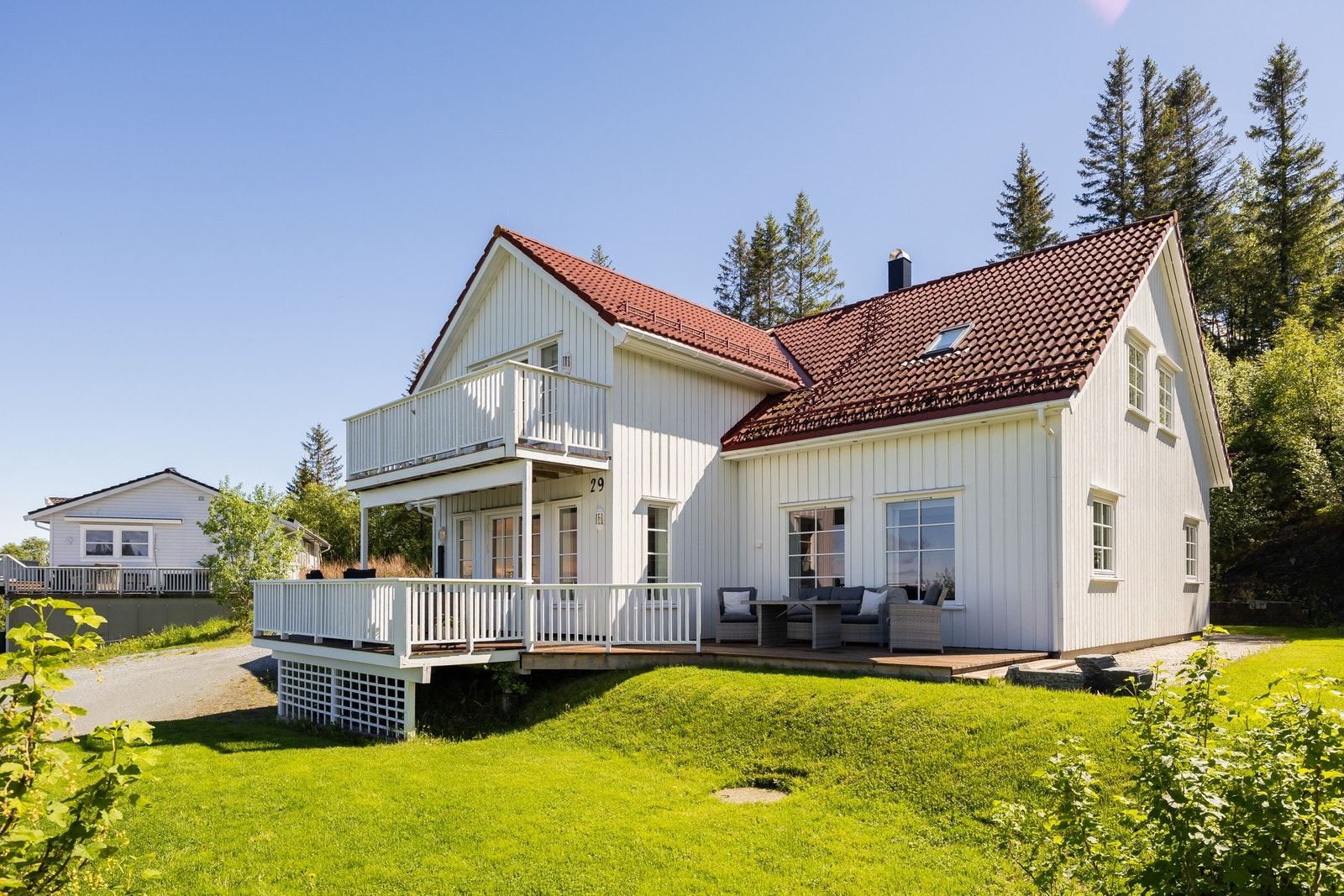 Man får solen på plattingen til høyre for huset, fra tidlig på dagen. Galleribilde