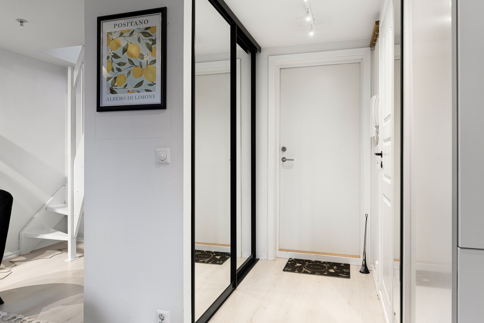 Vel inne blir vi ønsket velkommen i en pen entré med hvitmalte vegger og lys, enstavs laminat på gulvet. Galleribilde