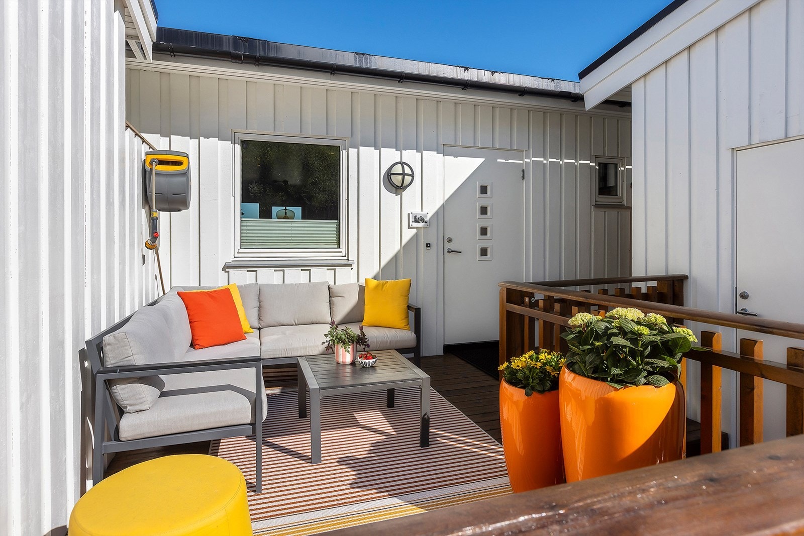 Terrasse med ettermiddagssol og inngang til sportsbod Galleribilde