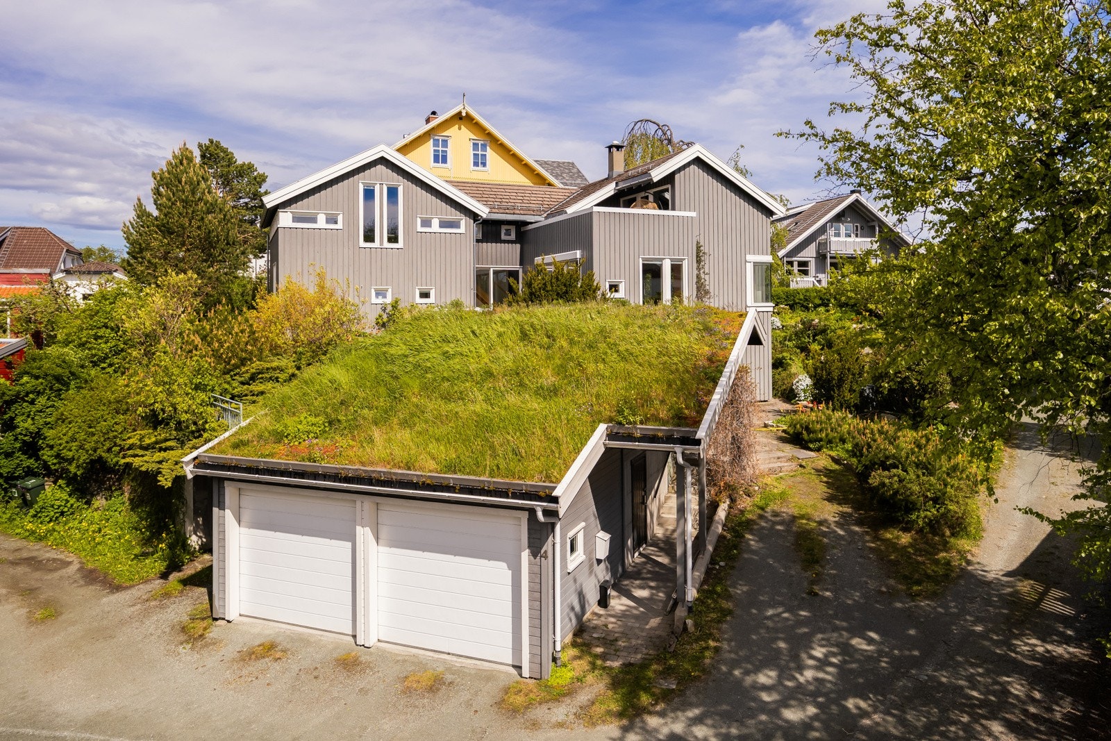 Dobbelgarasje og carport med kledelig torvtak og ytterligere parkeringsmuligheter. Galleribilde
