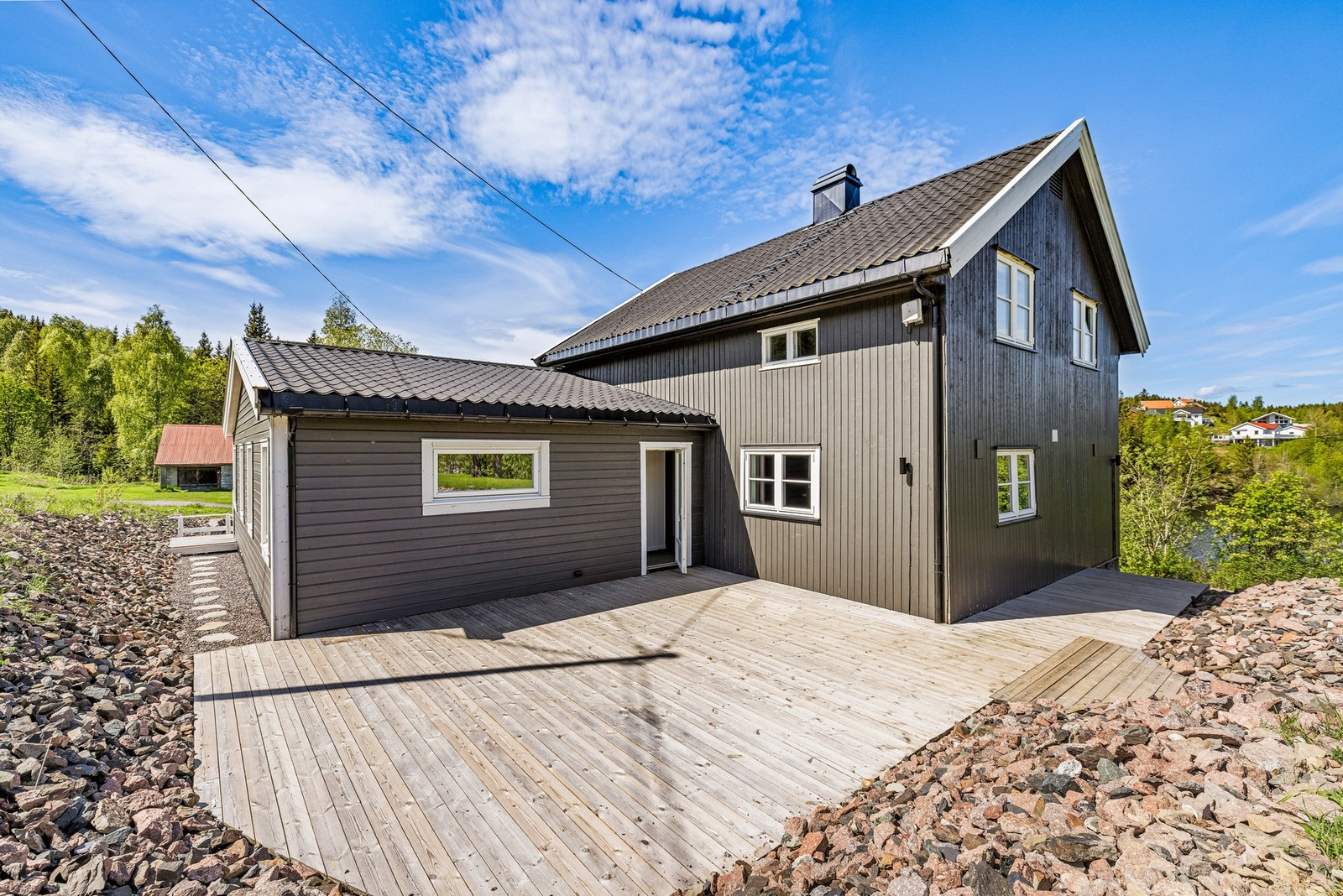 Terrasse på baksiden av huset er koblet til verandaen på fremsiden med en stenlagt sti. Galleribilde