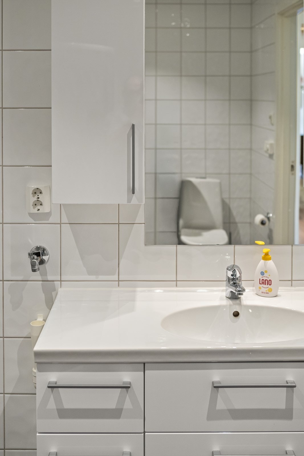 Detaljer fra badet, som viser servantinnredning og speilskap. Galleribilde