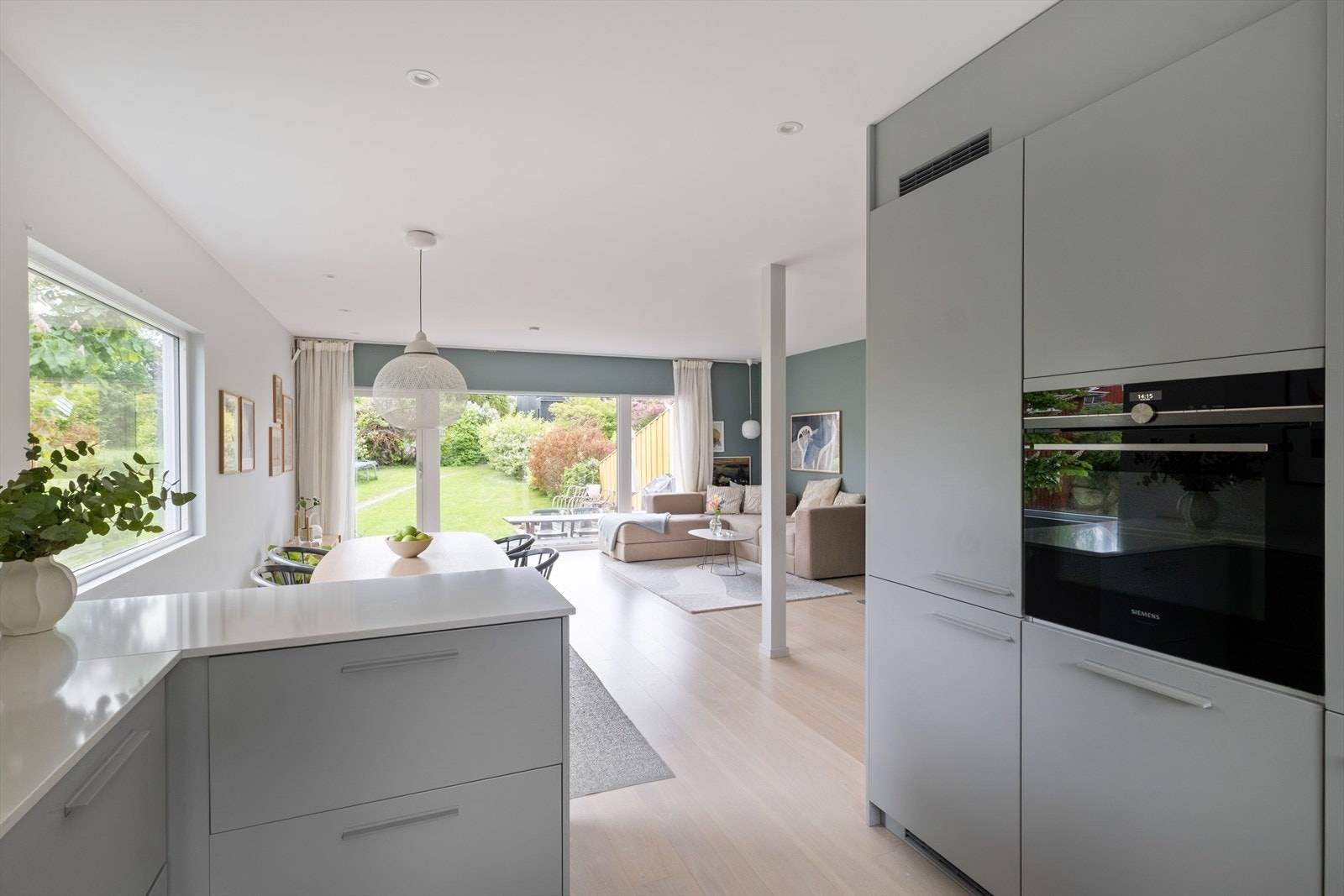 Den åpne løsningen mot stuen skaper en sosial og hyggelig atmosfære, med god plass til spisebord - perfekt for familiemiddager, gjester eller lekser mens middagen tilberedes. Galleribilde