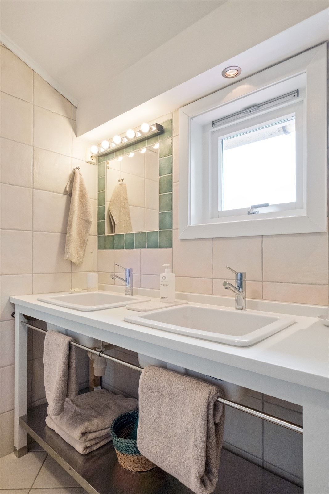 Badet er utstyrt med vegghengt toalett, innfliset boblebadekar med dusjgarnityr samt dobbel servant med oppbevaringsløsninger under. Galleribilde