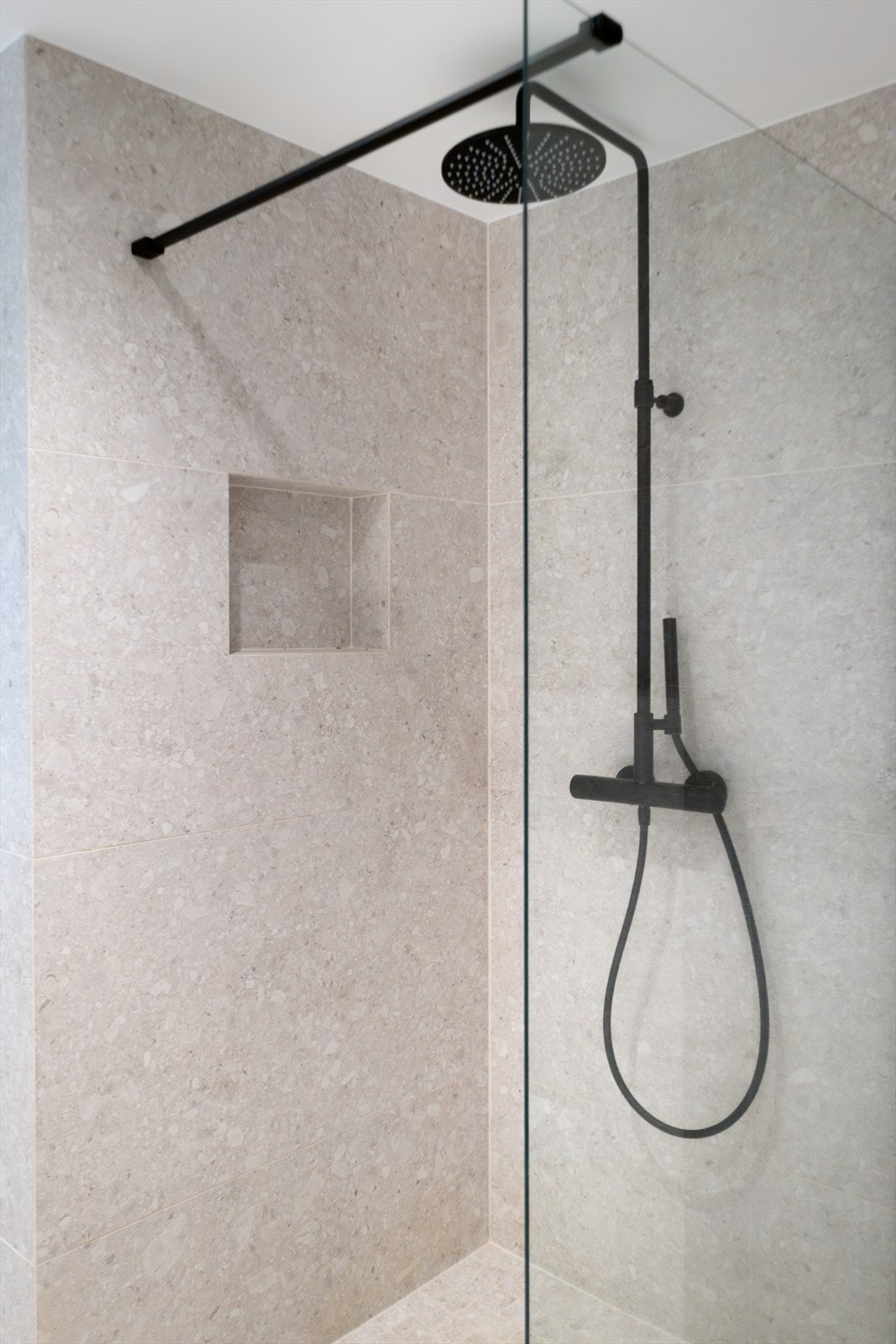 Gulvet er belagt med 60 x 60 cm fliser, med mindre mosaikkfliser i dusjsonen. Galleribilde