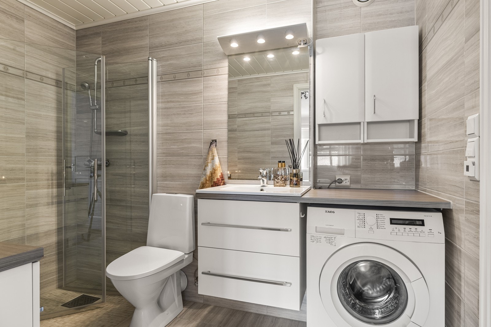 Badet er kombinert vaskerom med opplegg for vaskemaskin og tørketrommel. Galleribilde