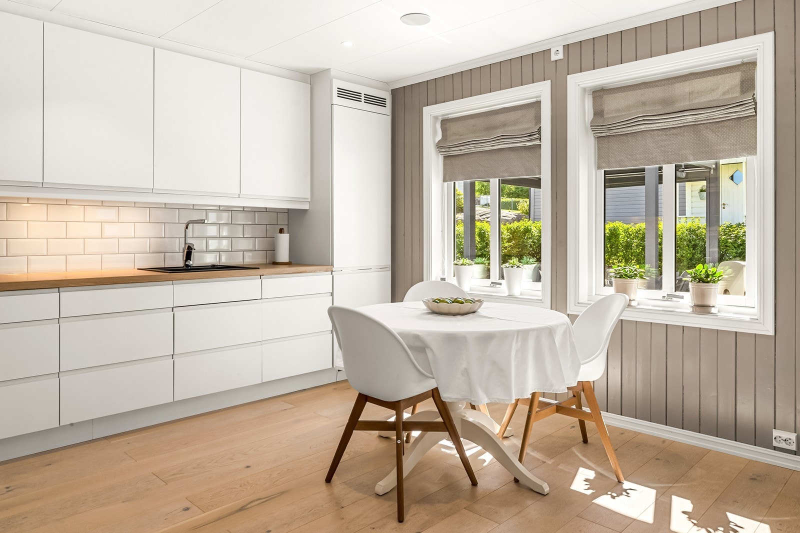 Kjøkkenet ligger i eget rom med plass til frokostbord for mindre måltider eller morgenkaffen. Store vinduer gir hyggelig utsyn mot egen uteplass. Galleribilde