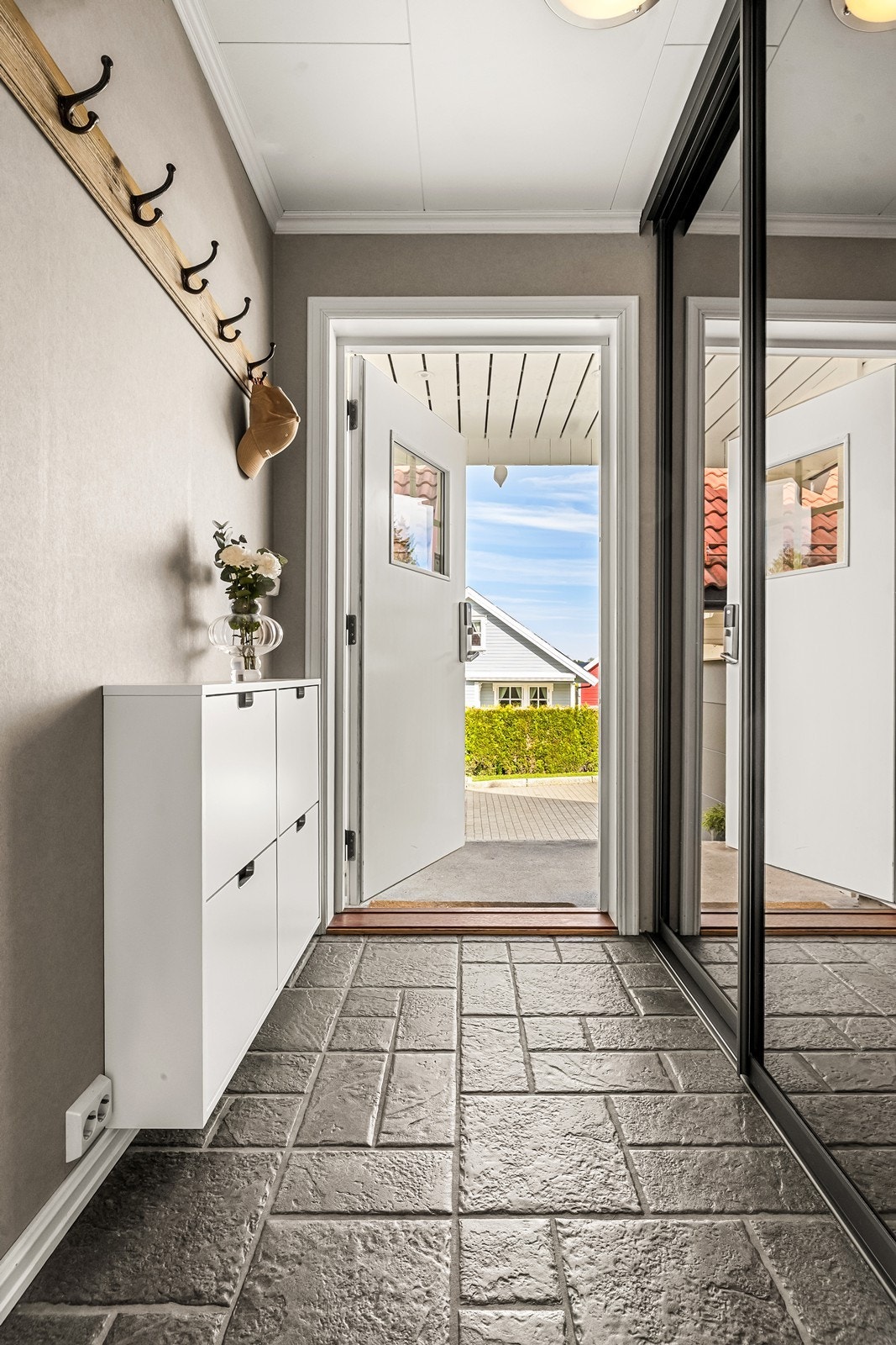 Vel inne tar et vindfang i mot med flislagt gulv, gulvvarme og skyvedørsgarderobe. Galleribilde
