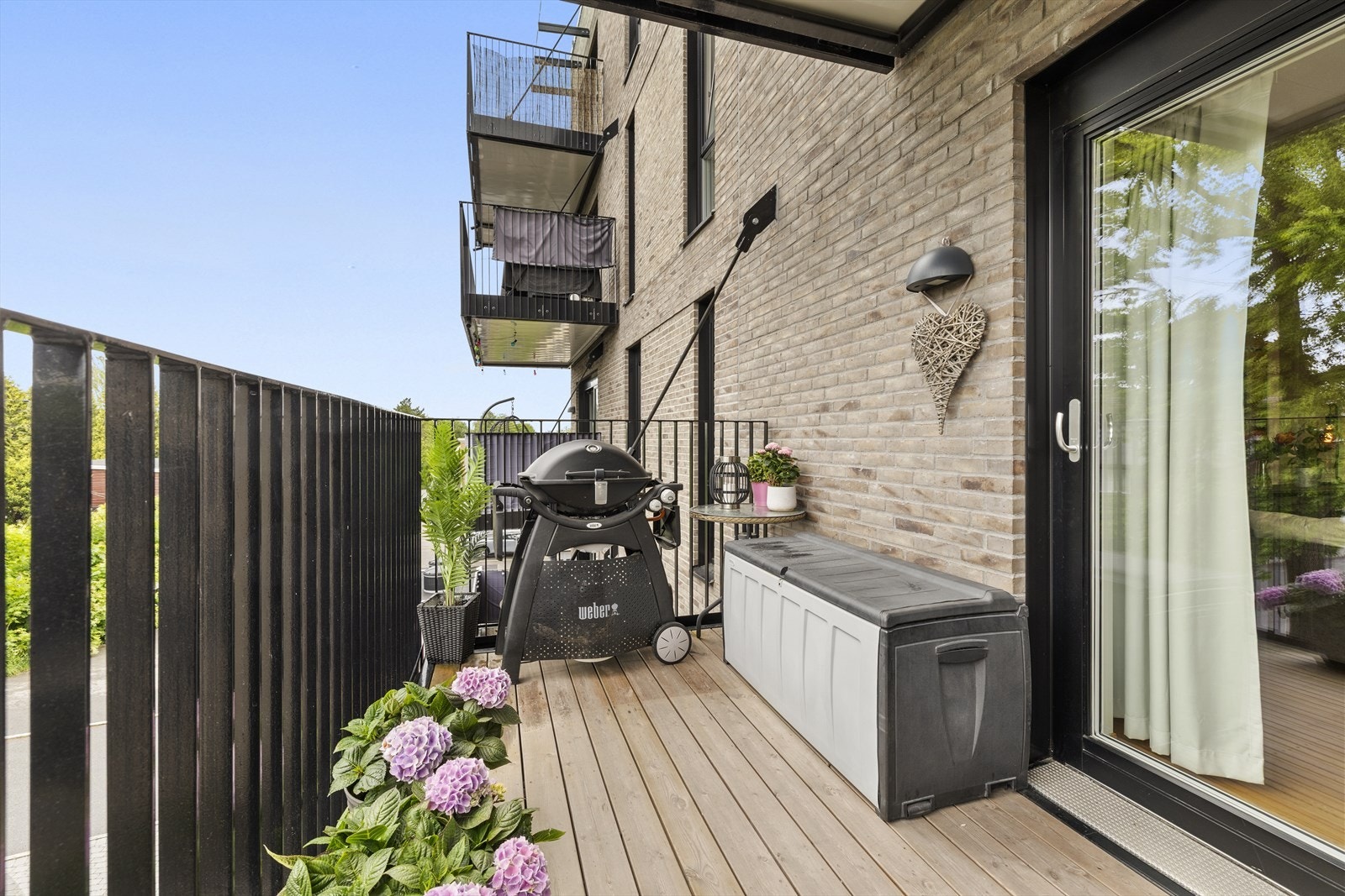 Balkongen har terrassebord, rekkverk med sorte stålspiler og utendørs belysning. Galleribilde