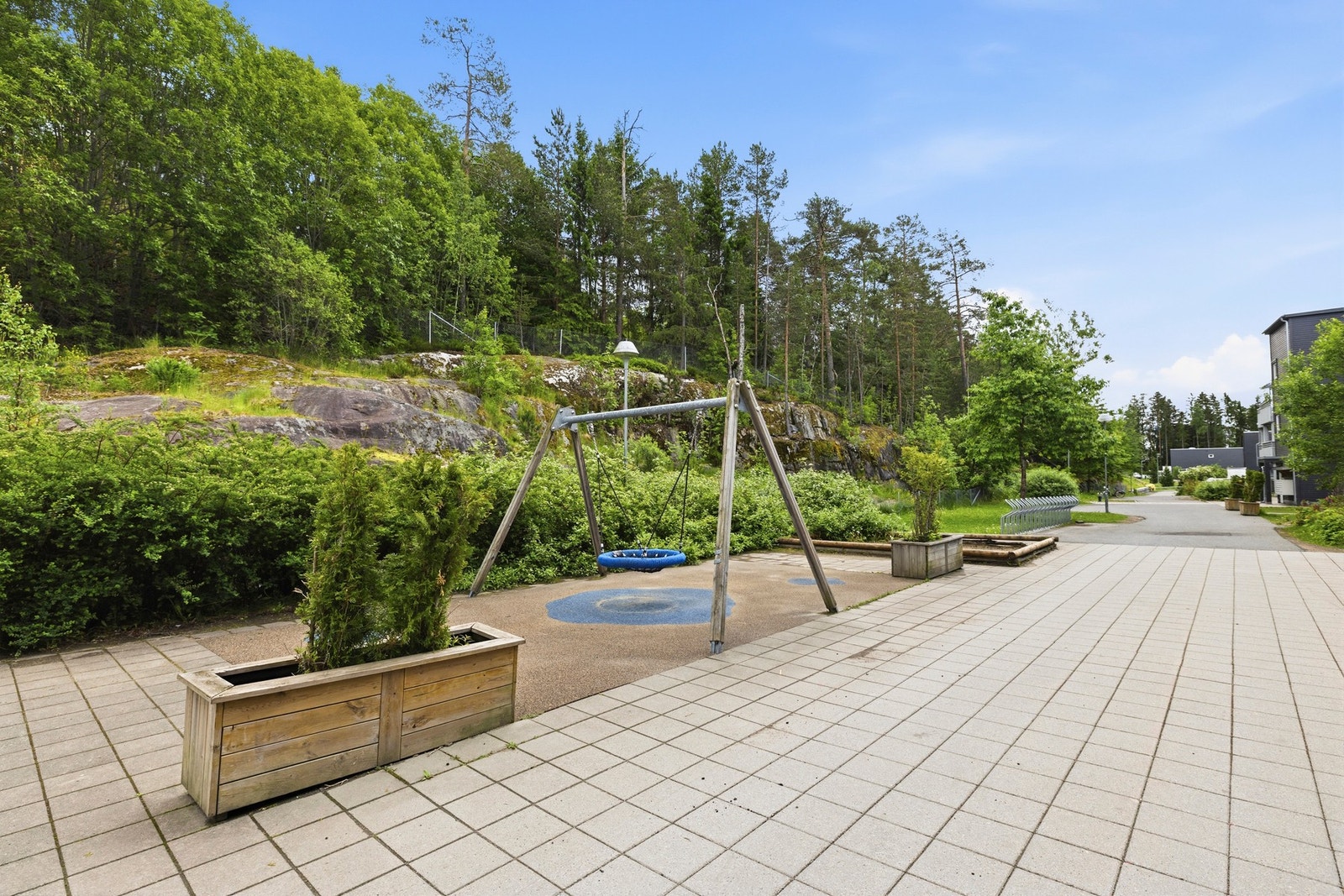 Steinbelagte fellesområder med beplantninger og lekeplass Galleribilde